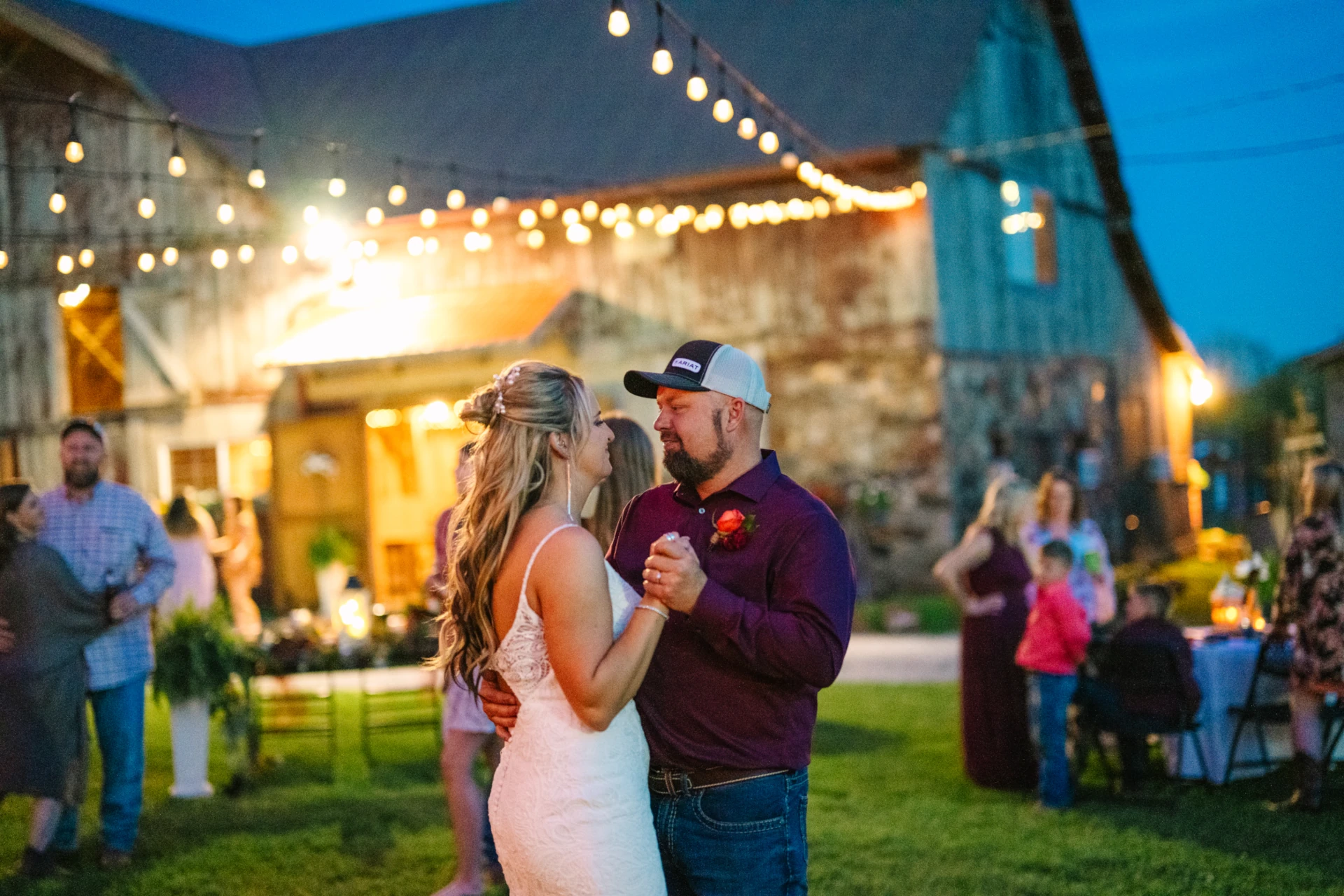 Wedding couple dances under lights in the courtyard at Civil War Ranch